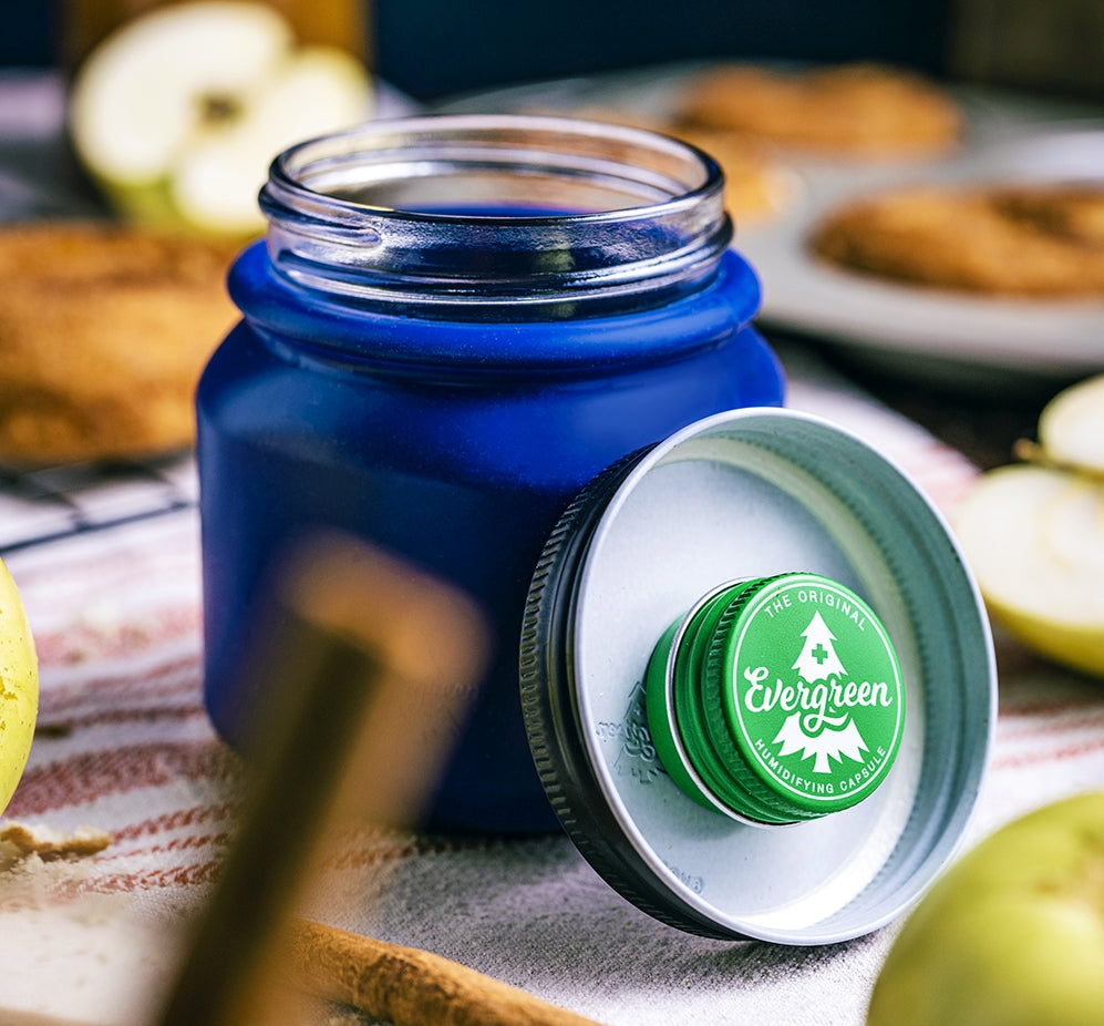 Blue Evergreen Storage Solution jar open on table showing pod