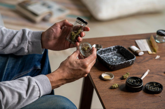 person holding two cannabis jars