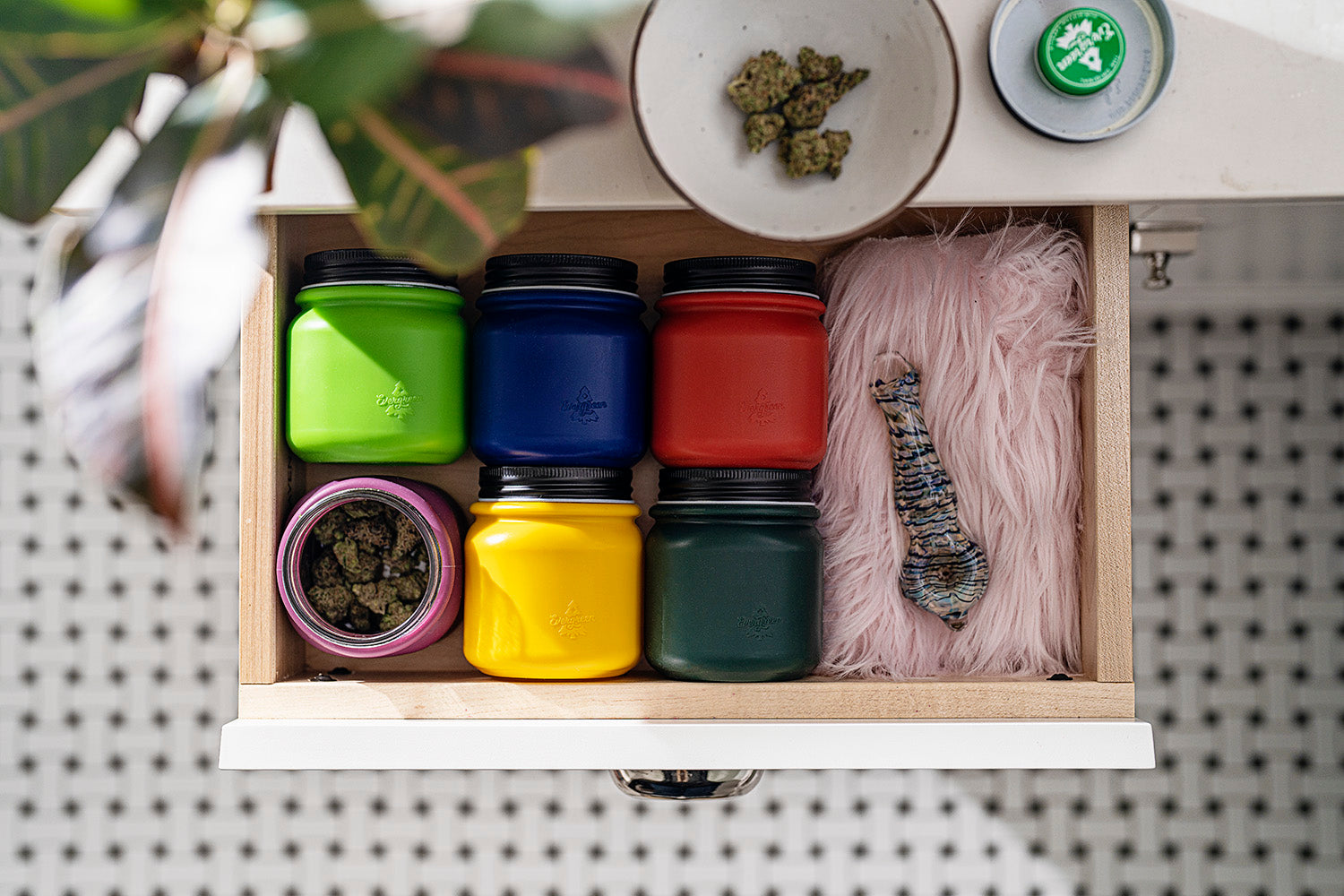 Evergreen Storage Solution jars in six colors in an open drawer with pipe and cannabis flower